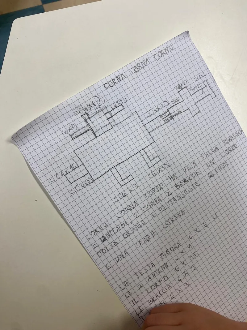 Foglio a quadretti con il progetto di un robot in pixel art e le misure di ogni parte.