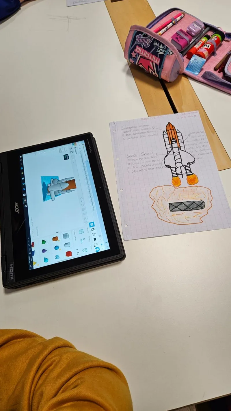 Disegno tecnico di uno Space Shuttle accanto al suo modello 3D sul portatile.